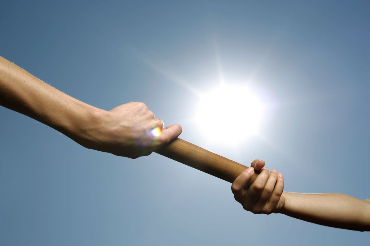Two hands passing a relay baton under bright sunlight, representing fragmented Lambda invocations each handling a brief burst of work before disappearing, rather than one continuous worker process