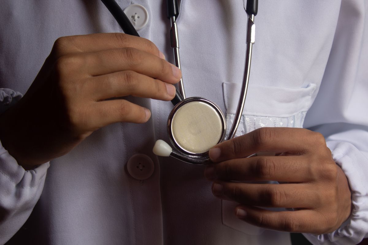 A doctor holding a stethoscope during a checkup, representing a health check that actually verifies the right thing