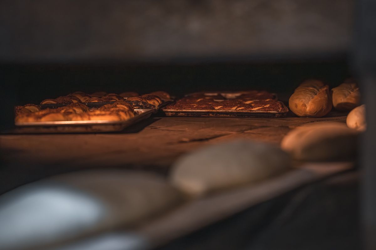 Fresh loaves of bread and pastries sitting inside a warm, glowing oven, representing an environment variable value that gets permanently baked into the JavaScript bundle at build time