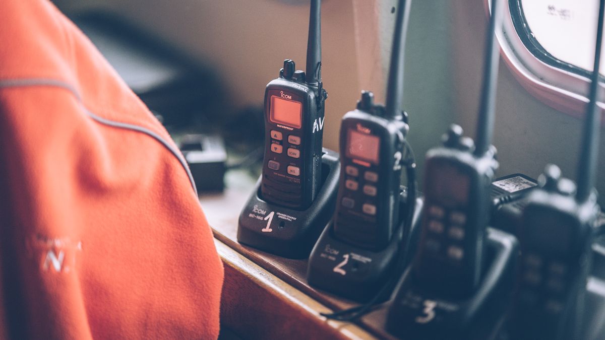 Wireless walkie-talkies sitting in charging docks, representing an HTTP-based edge-compatible driver replacing a persistent TCP connection Prisma can't hold open in this runtime