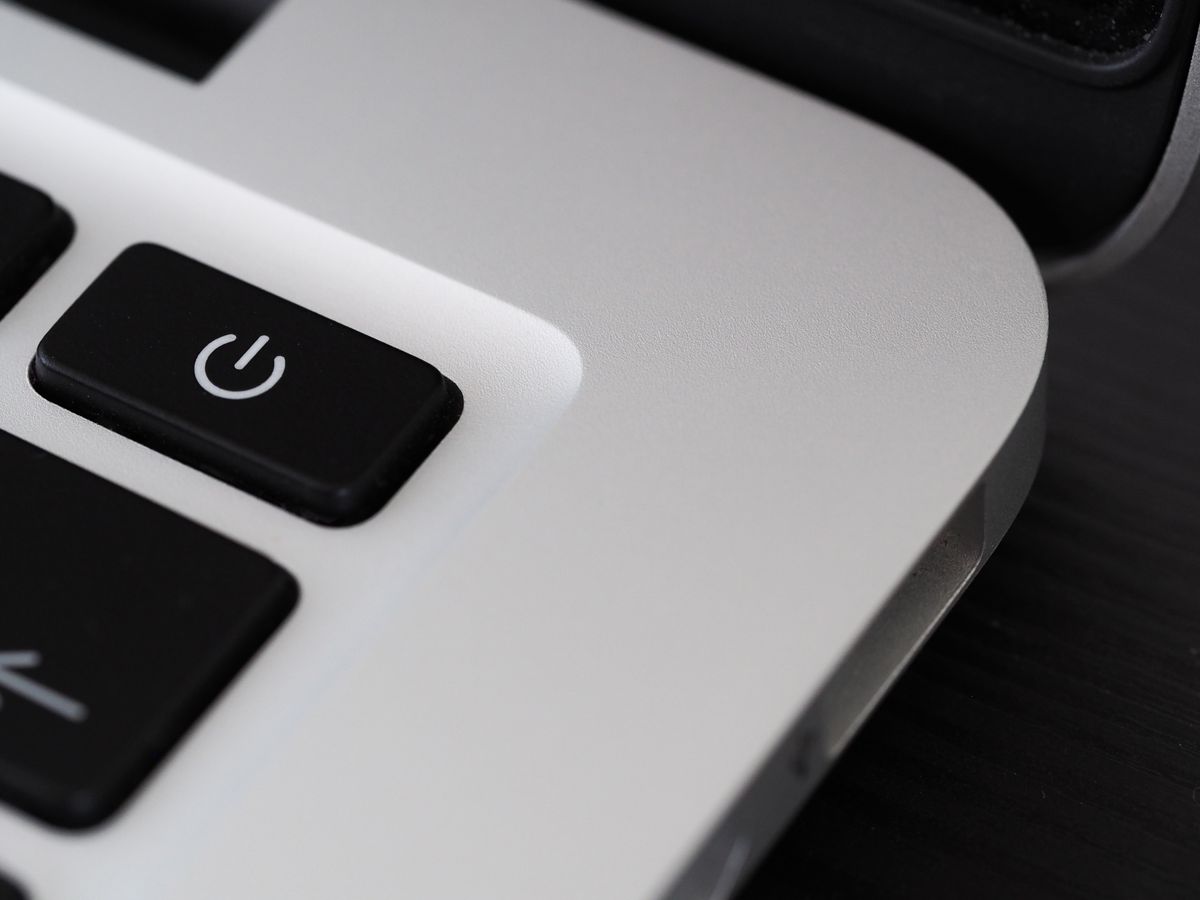 A detailed close-up of an orange power button, representing the app restart that runs schedule-registration code every single time, not just once